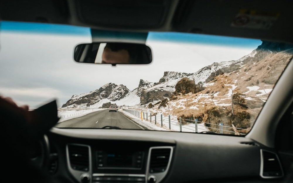 Car dashboard and windscreen view of a mountain road