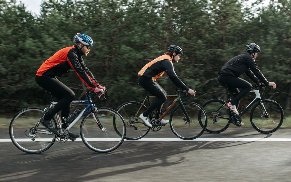 Cyclists in sportswear riding along a road